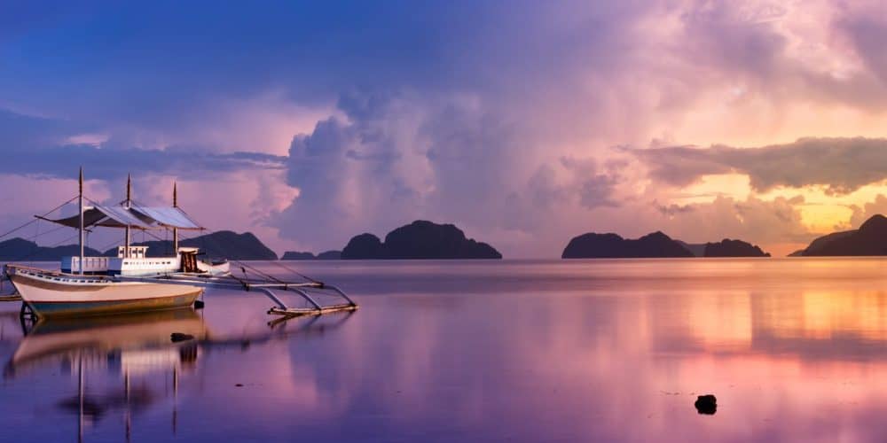 Tropical sunset with a banca boat in Palawan - Philippines